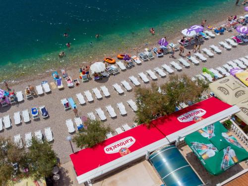 an overhead view of a beach with chairs and umbrellas at Apartments Sentic in Neum
