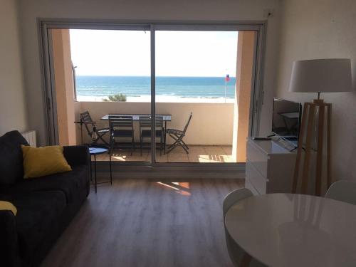 a living room with a couch and a view of the ocean at Studio pleine vue sur l'océan - Soulac sur Mer in Soulac-sur-Mer