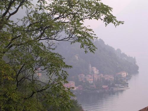 a village on a hill next to a body of water at Caffè del Viaggiatore in Valsolda