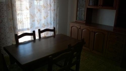 a dining room table with two chairs and a window at Appartamento grazioso e confortevole a Orbetello (GR) in Orbetello
