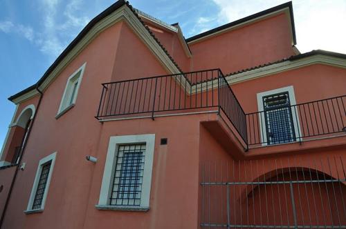 a red building with a staircase on the side of it at B&B Ai Catalani in Beltiglio