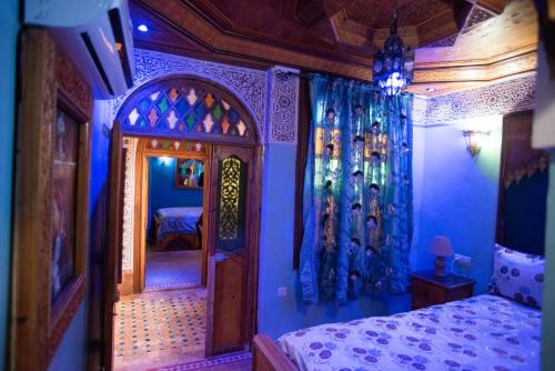 a bedroom with a bed and a mirror in it at Riad Mehdi Meknès in Meknès