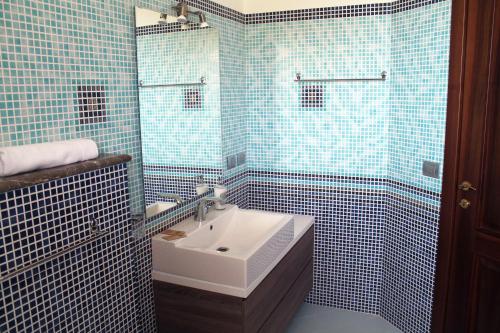 a blue tiled bathroom with a sink and a shower at Villa i Minnulareddi in Giardini Naxos