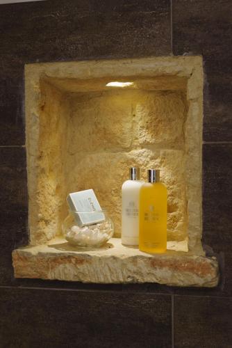 two bottles ofodorizers sitting on a stone shelf at Serenity Boutique House in Vouni