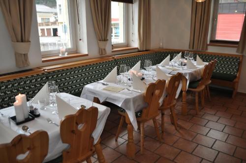 une salle à manger avec des tables et des chaises blanches dans l'établissement Ski Lodge Jaktman, à Bad Gastein