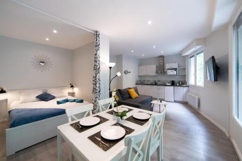 um quarto e sala de estar com uma cama e uma mesa de jantar em L'ALCÔVE Saint GEORGES ★ Au cœur de TOULOUSE em Toulouse
