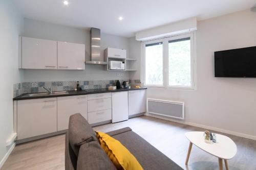 un salon avec un canapé et une cuisine dans l'établissement L'ALCÔVE Saint GEORGES ★ Au cœur de TOULOUSE, à Toulouse