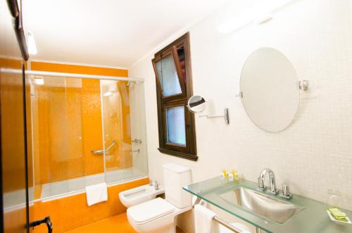 uma casa de banho com um lavatório, um WC e um chuveiro em Hotel Guaminí Misión em Puerto Iguazú
