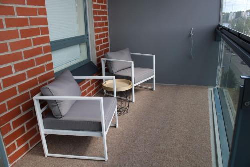 two chairs and a table in front of a brick building at Menuetti - best lake view in Jyväskylä
