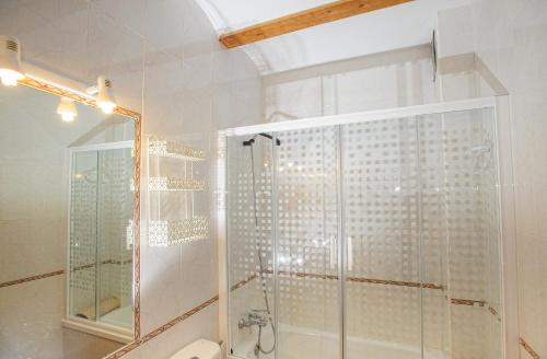 y baño con ducha y ducha acristalada en la puerta trasera. en Casa Rural La Herradura del río Júcar, en Jorquera