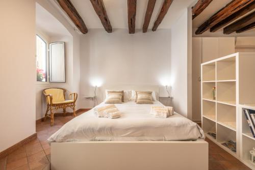 una camera da letto con un grande letto bianco e una sedia di Remy apartment a Cagliari