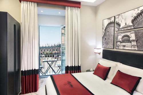 um quarto com uma cama com almofadas vermelhas e uma janela em Citykey Napoli - Bed & Breakfast em Nápoles