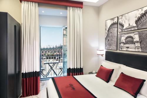 a bedroom with a bed with red pillows and a window at Citykey Napoli - Bed & Breakfast in Naples