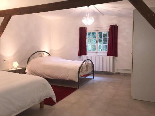 - une chambre avec 2 lits et une fenêtre avec des rideaux rouges dans l'établissement Maison en bord de seine, à Boissise-le-Roi