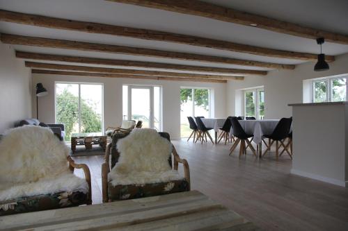 a living room with chairs and a table and windows at Stevns Klint Strandpension in Rødvig