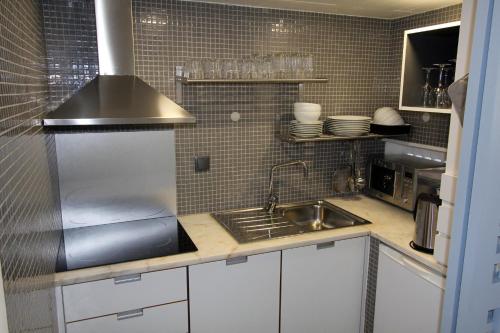 a small kitchen with a sink and a stove at Victory Village Club, Quinta do Lago in Quinta do Lago