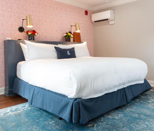 a large bed in a bedroom with a blue rug at The Germantown Inn in Nashville