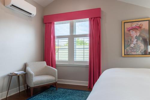 a bedroom with a bed and a window and a chair at The Germantown Inn in Nashville