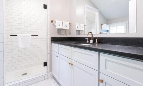 a white bathroom with a sink and a mirror at The Germantown Inn in Nashville