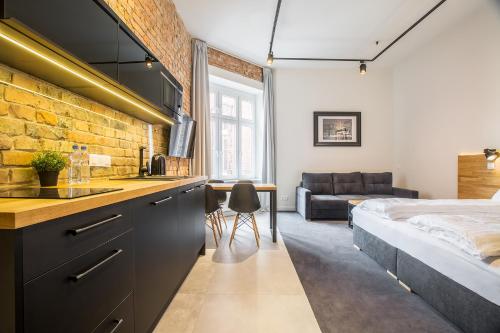 ein Schlafzimmer mit einem Bett und eine Küche mit einem Waschbecken in der Unterkunft Loft Apartments Poznań in Posen