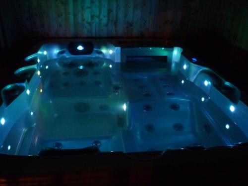 a bath tub with lights in a dark room at R1 Rolléder Apartman-ház in Siklós