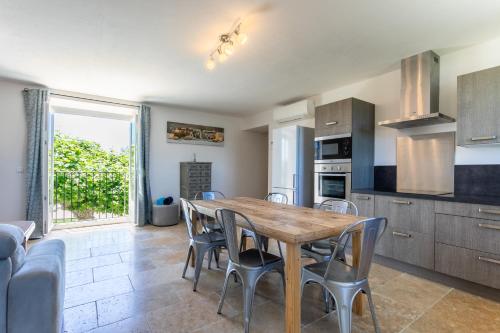a kitchen and dining room with a wooden table and chairs at Mas Saint Julien in Cavaillon