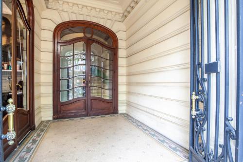 un pasillo vacío con una puerta de madera en un edificio en Appart Hypercentre - Le Clemenceau, en Burdeos