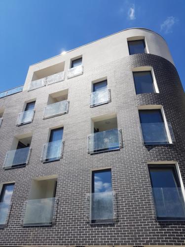 a tall brick building with windows on it at Zielone Apartamenty Katowice Chorzów in Chorzów