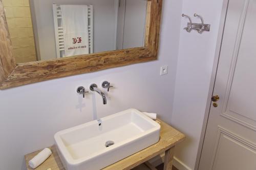 a bathroom with a white sink and a mirror at Logis de la Cadène in Saint-Émilion