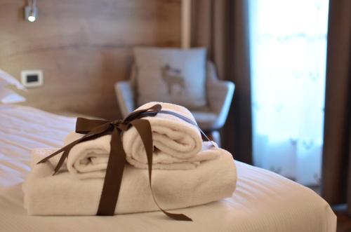 a pile of towels sitting on top of a bed at X Alp Hotel in Pozza di Fassa