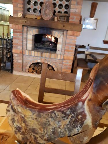 a stone fireplace in a room with a chair in front at B&B OPG Culig in Ozalj