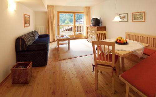 a living room with a table and a dining room at Biotel Bertel Naturappartements in Brand