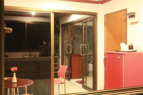 a kitchen with a small table and a red refrigerator at Chaweng Noi Resort in Chaweng Noi Beach