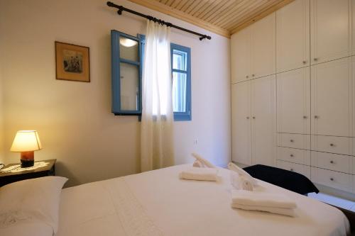 um quarto com uma cama branca e uma janela em Under the Windmills em Kondiás