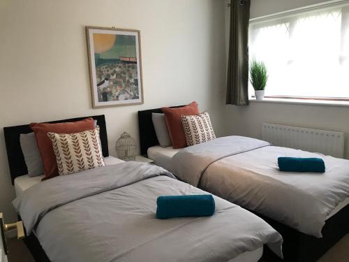 1 dormitorio con 2 camas con almohadas en Swale Corner en Wellingborough