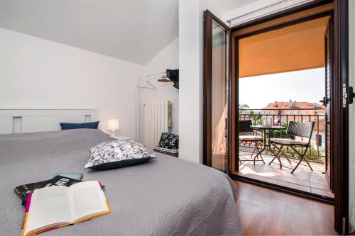 um quarto com uma cama com um livro e uma varanda em Apartment Len em Rovinj