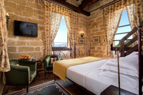 Schlafzimmer mit einem Bett, einem TV und Fenstern in der Unterkunft Hotel Baglio Oneto dei Principi di San Lorenzo - Luxury Wine Resort in Marsala