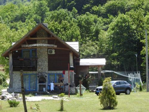a small house with a car parked in front of it at Exo Log Cottage in Jezero