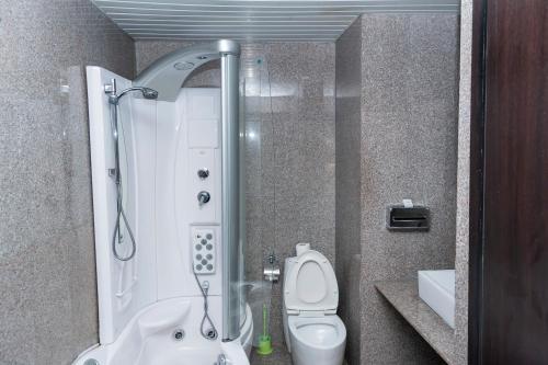 a small bathroom with a shower and a toilet at Hawthorn Suites by Wyndham Abuja in Abuja