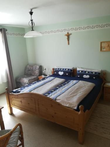 1 cama en un dormitorio con una cruz en la pared en Hanslbauernhof en Moosbach