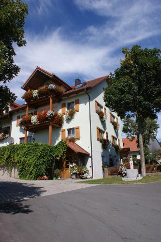 ein großes weißes Gebäude mit Blumenkästen drauf in der Unterkunft Hanslbauernhof in Moosbach