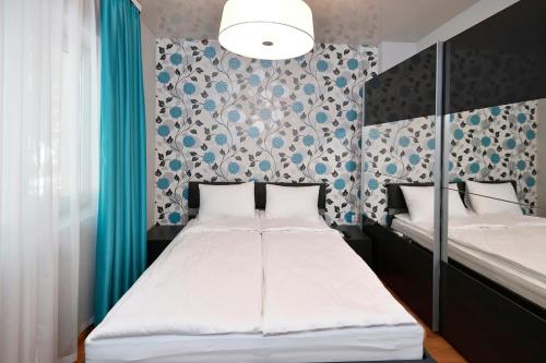 1 dormitorio con 2 camas y papel pintado azul y blanco en Varchev 1, en Varna