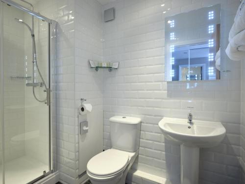 a white bathroom with a toilet and a sink at MILL Hotel & Spa in Chester
