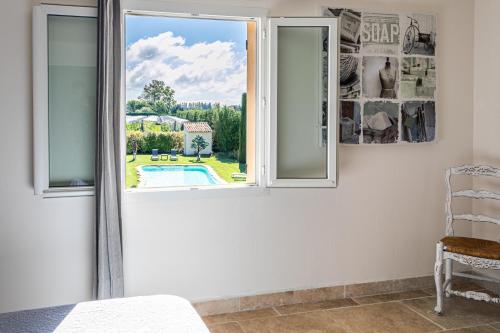 a bedroom with a window with a view of a pool at Mas Saint Julien in Cavaillon