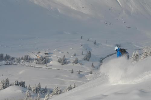 a person is skiing down a snow covered slope at Ski Lodge Jaktman in Bad Gastein