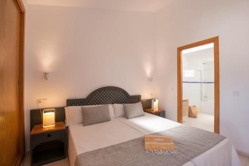 a bedroom with a bed with two lamps and a mirror at Cabot Siller Apartment in Port de Pollensa
