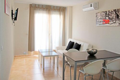 sala de estar con mesa y sofá en Apartamentos Doña Carmen 3000, en Oropesa del Mar