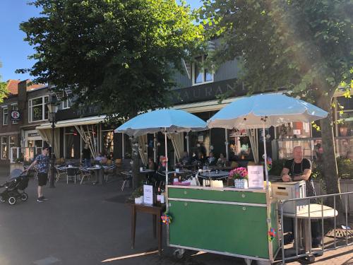 a food cart with two umbrellas on a street at Hotel Nap in West-Terschelling