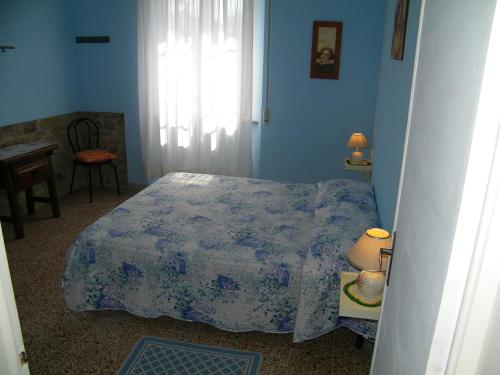 een blauwe slaapkamer met een bed en een raam bij Home89 in Lucca