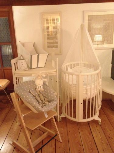 a room with a crib and a chair and a table at Vier Jahreszeiten Idyll in Schuttertal